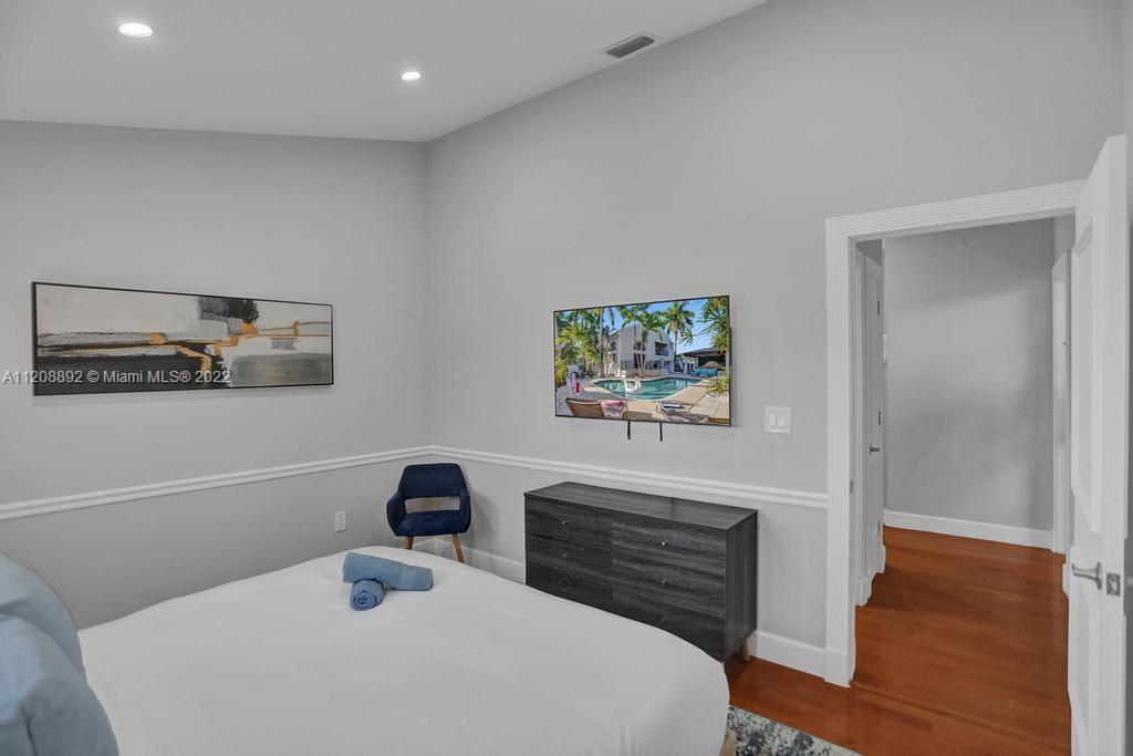 960 Northwest 4th Court Boca Raton, FL 33432 - Photo 65 of 75 a bedroom with a bed and a painting on the wall