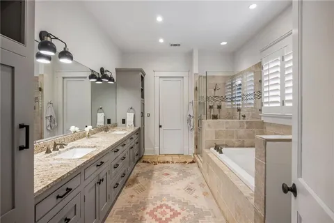 a bathroom with a granite countertop sink mirror bathtub and shower