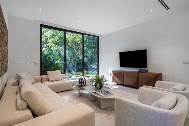a living room with patio furniture and a garden