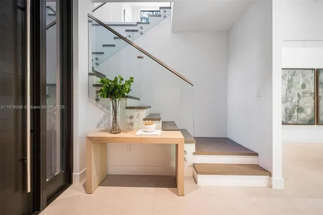 a living room with furniture a large window and a potted plant