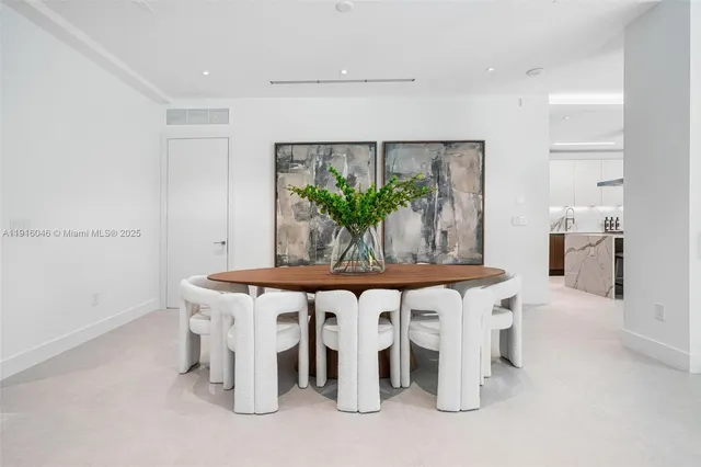 a kitchen with stainless steel appliances kitchen island granite countertop a table chairs sink and cabinets