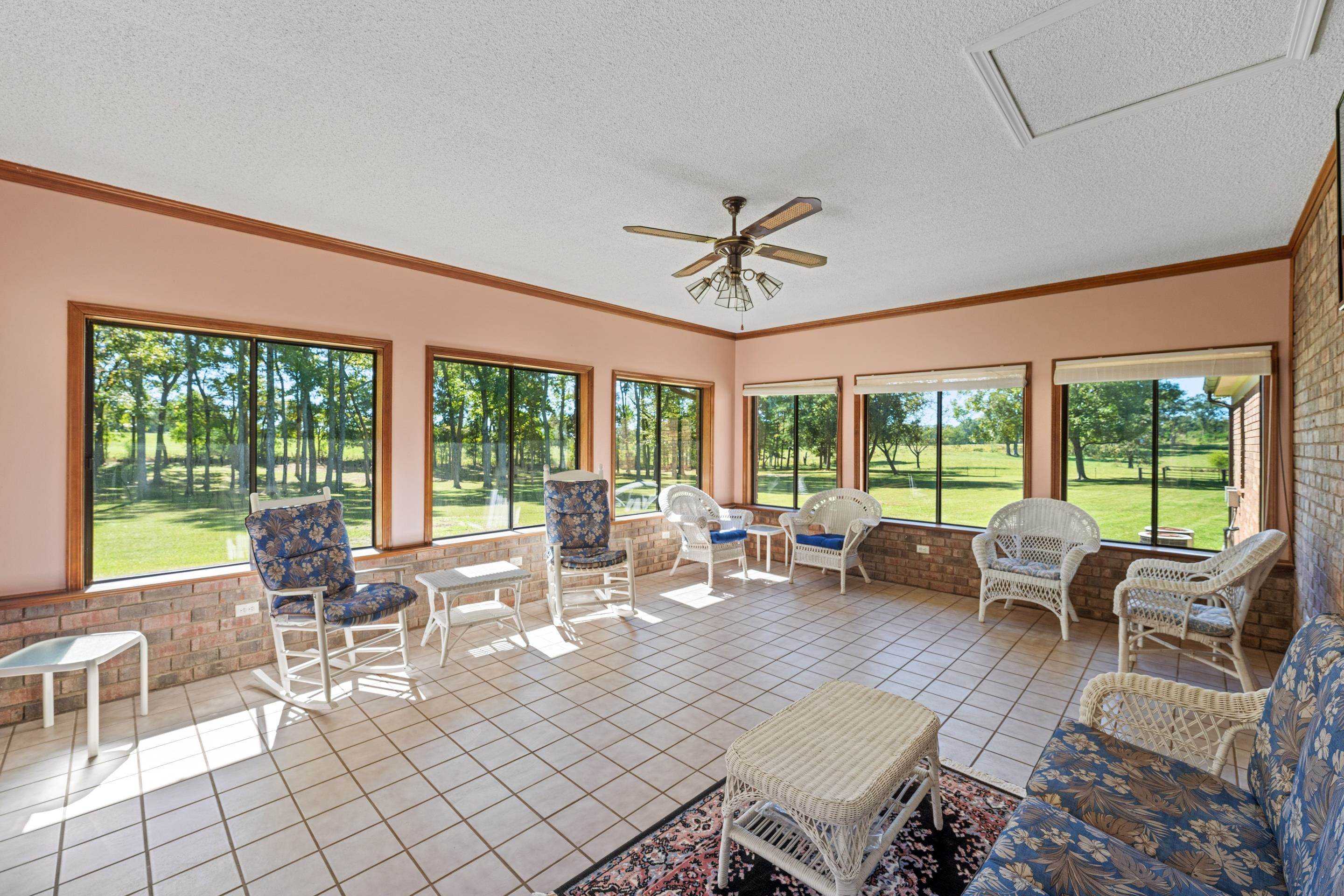 650 Blain Road Rossville, TN 38066 - Photo 12 of 26 This inviting sunroom combines elegance and practicality with its tile floor, ceiling fan, and timeless brick wall. Windows on every side provide panoramic views and fill the room with natural light, creating a bright, airy space for relaxing.