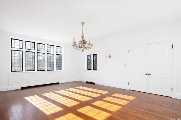 a view of a bedroom with wooden floor and windows