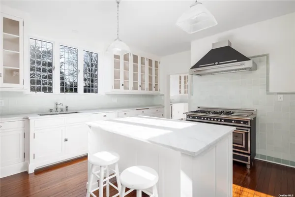a kitchen with a stove a window and cabinets