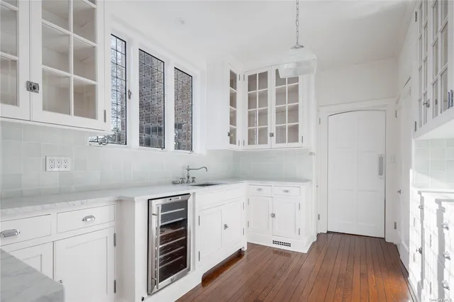 a kitchen with granite countertop white cabinets and wooden floor