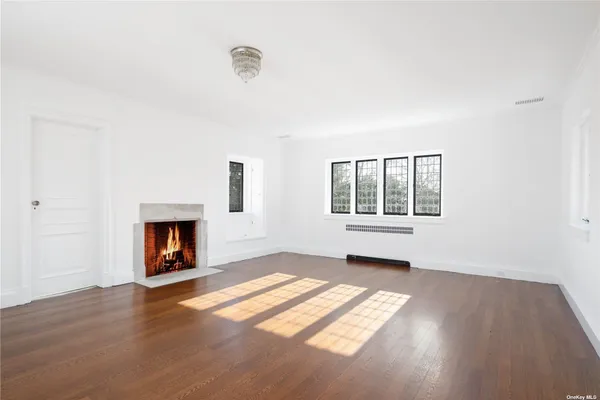 an empty room with windows and fireplace
