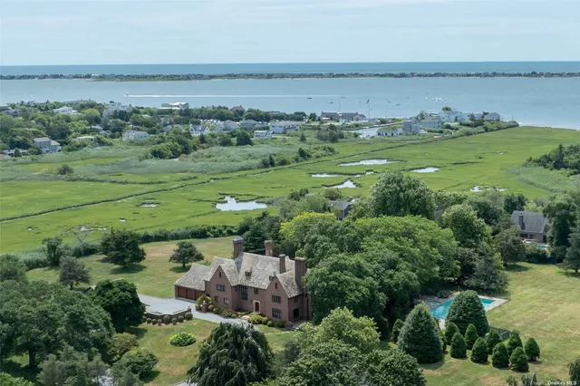 an aerial view of a houses with a yard and lake view