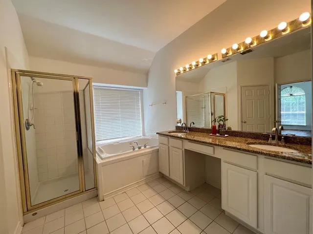 a bathroom with a tub a sink and mirror