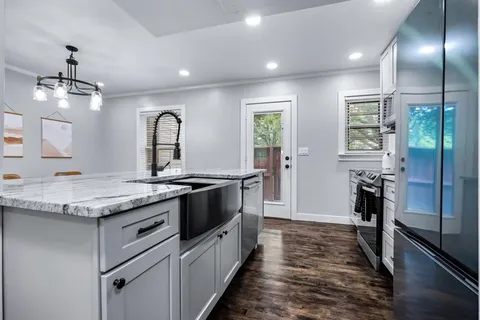 a kitchen with granite countertop a stove and cabinets