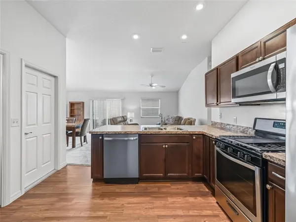a kitchen with stainless steel appliances granite countertop a stove top oven microwave and cabinets
