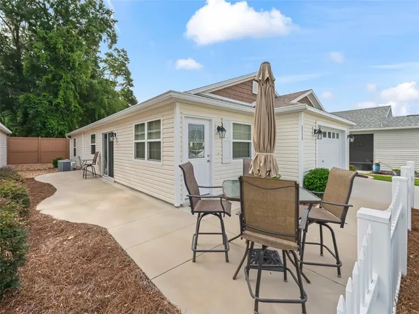 a view of a house with backyard and sitting area