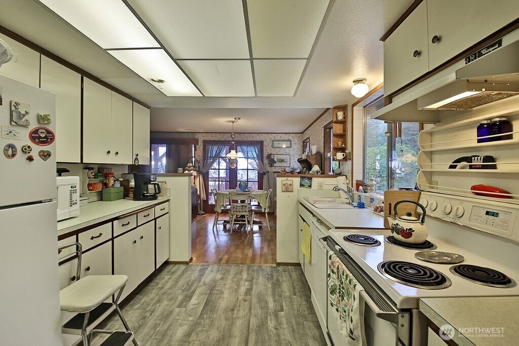 6423 South Admiralty Way Freeland, WA 98249 - Photo 6 of 11 a kitchen with a stove a refrigerator and a dining table