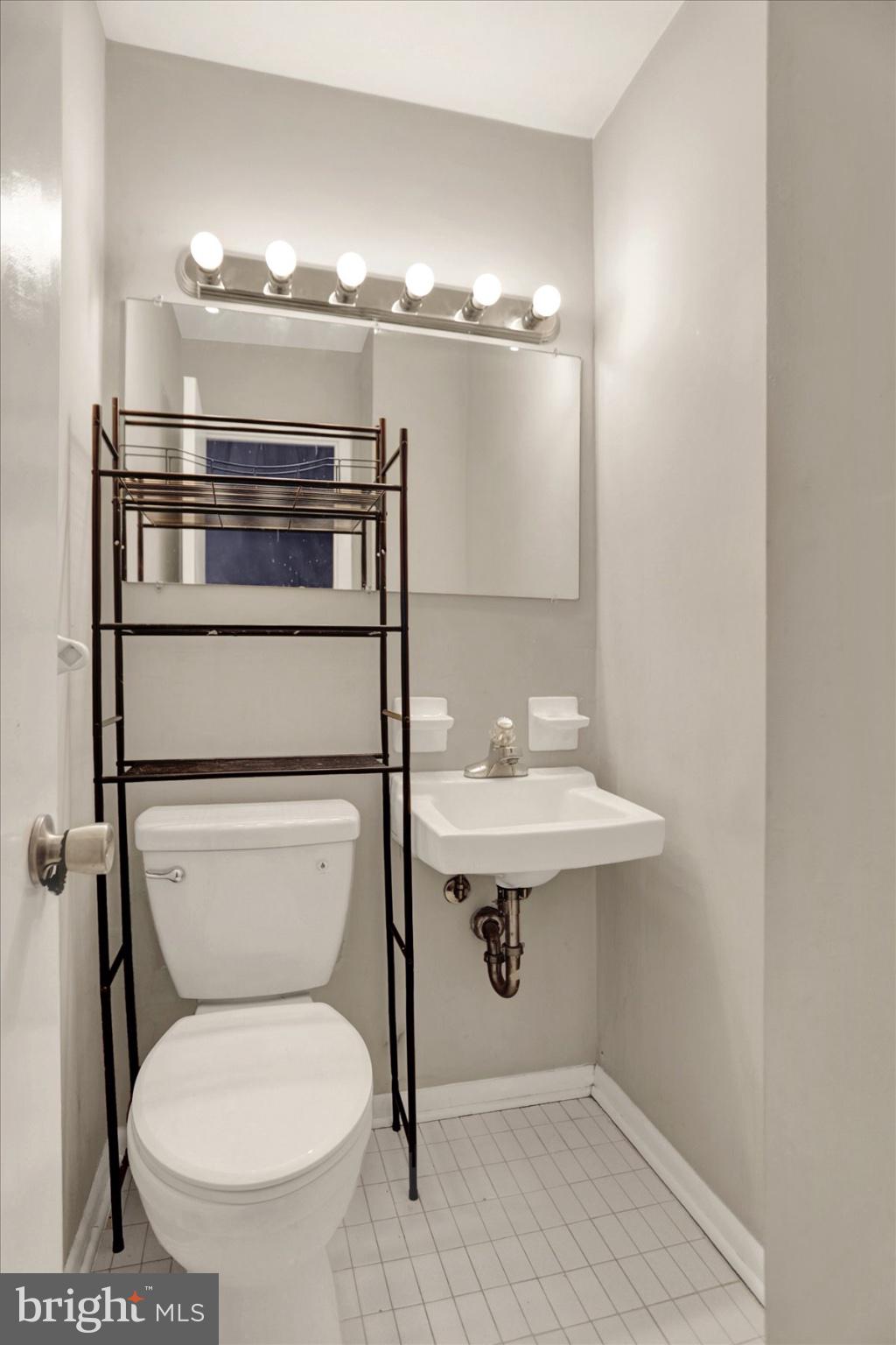 959 Elm Road Baltimore, MD 21227 - Photo 9 of 27 a bathroom with a toilet a sink and mirror
