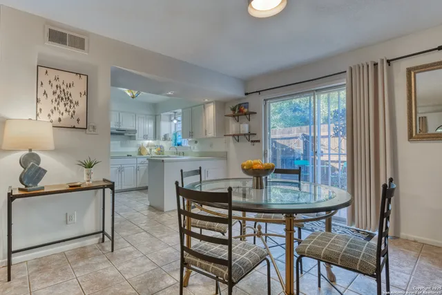 a kitchen with a dining table chairs and refrigerator