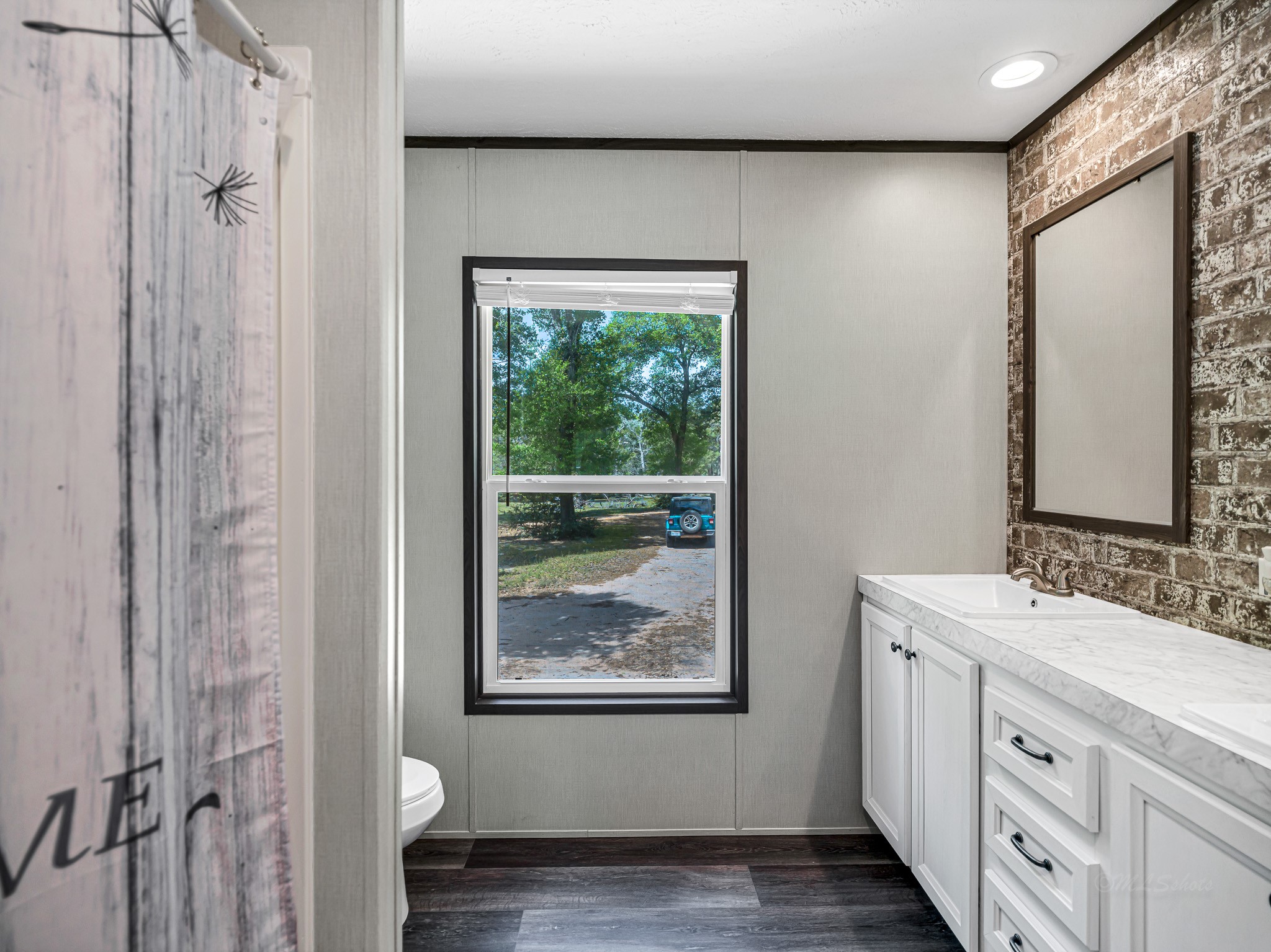 1047 Jimbob Lane New Ulm, TX 78950 - Photo 12 of 18 The secondary bathroom features a dual vanity with a granite style finish and a rustic brick patterned accent wall for that outdoorsy feel!