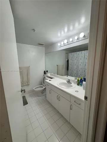 a bathroom with a double vanity sink mirror and toilet