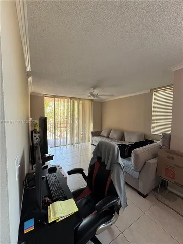 a living room with furniture gym equipment and a large window