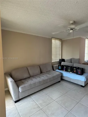 a living room with furniture and a ceiling fan