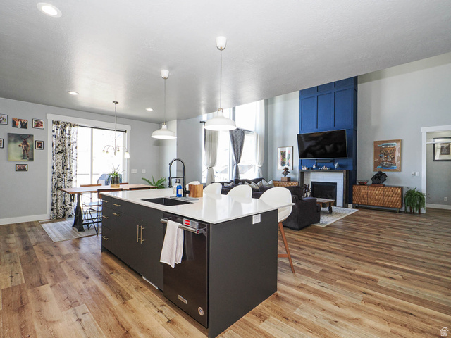 2487 Canyon Wild Road, Unit 413 Draper, UT 84020 - Photo 25 of 75 Kitchen with a breakfast bar area, hanging light fixtures, dishwasher, and light wood-style floors
