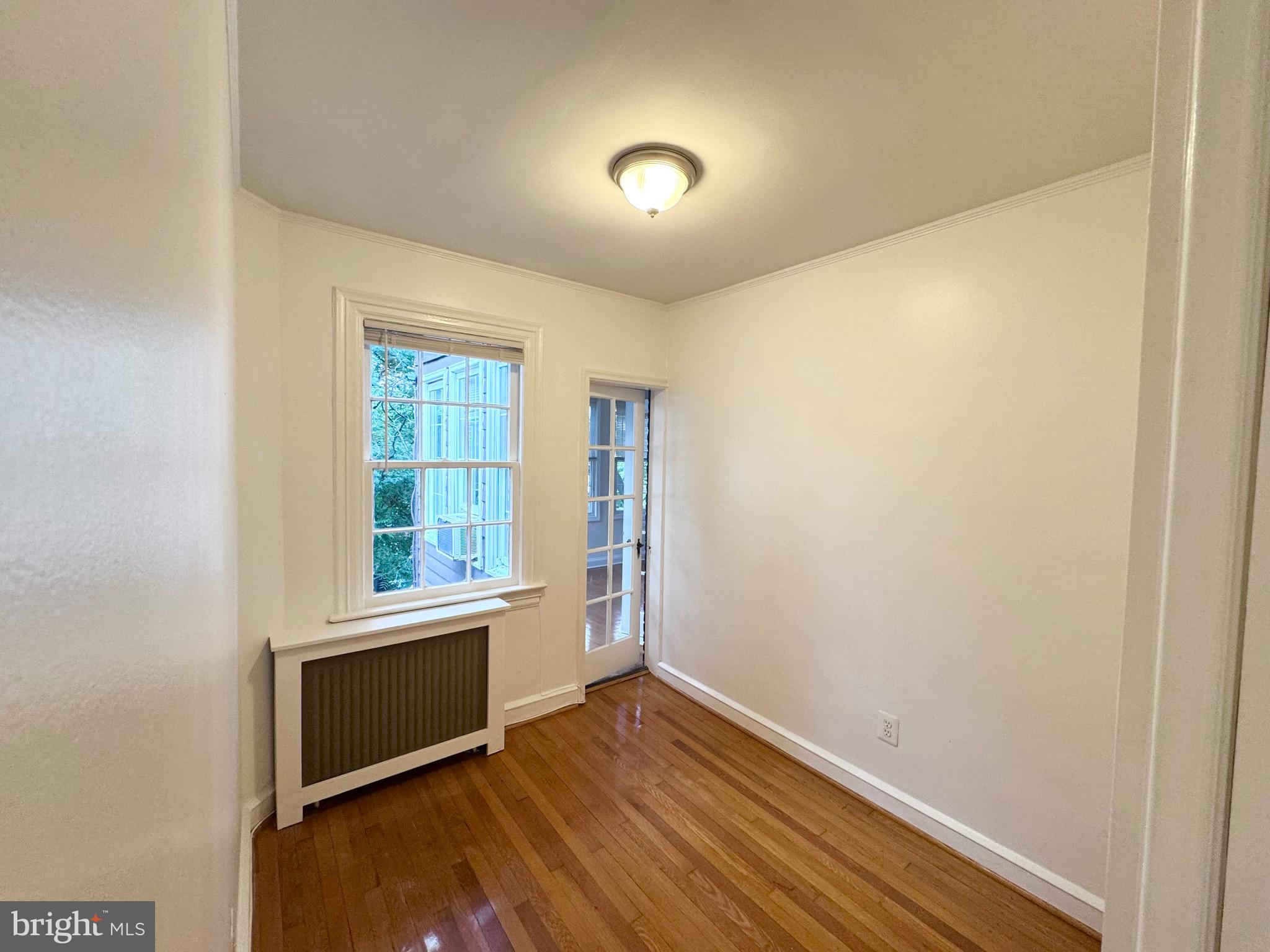 4417 Volta Place Northwest Washington, DC 20007 - Photo 21 of 38 an empty room with wooden floor and windows