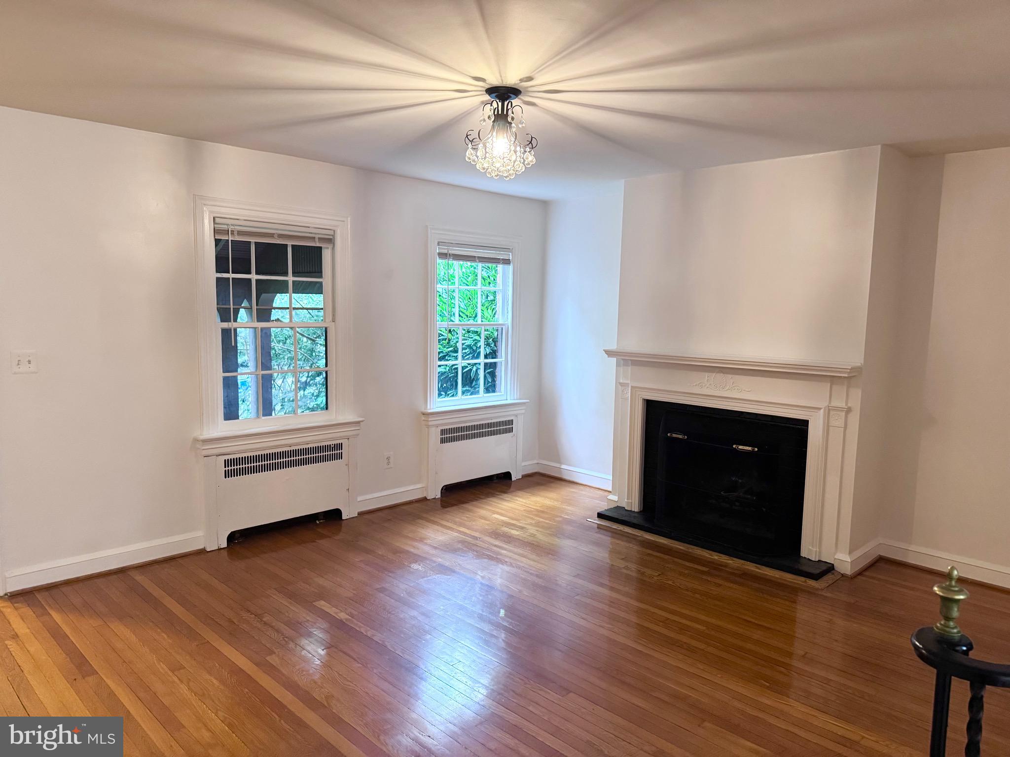 4417 Volta Place Northwest Washington, DC 20007 - Photo 8 of 38 wooden floor fireplace and windows in an empty room