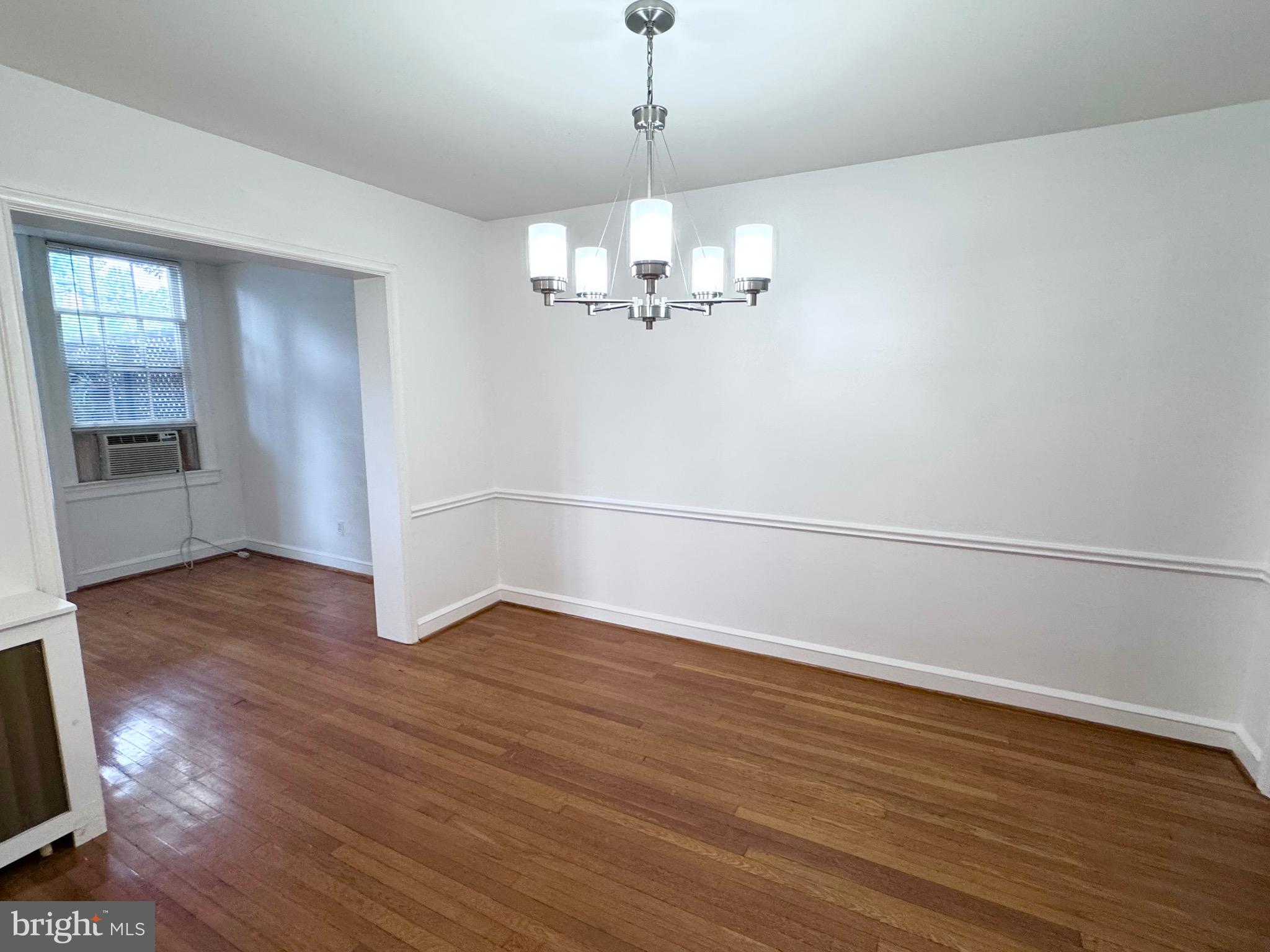4417 Volta Place Northwest Washington, DC 20007 - Photo 10 of 38 a view of an empty room with wooden floor and kitchen view