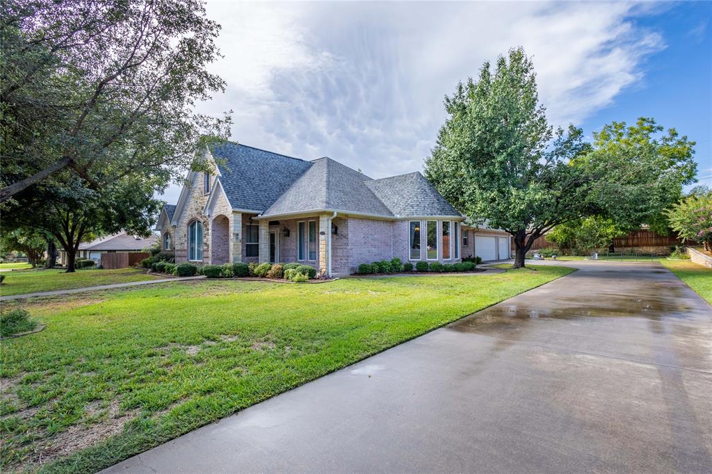 a front view of a house with a yard and trees
