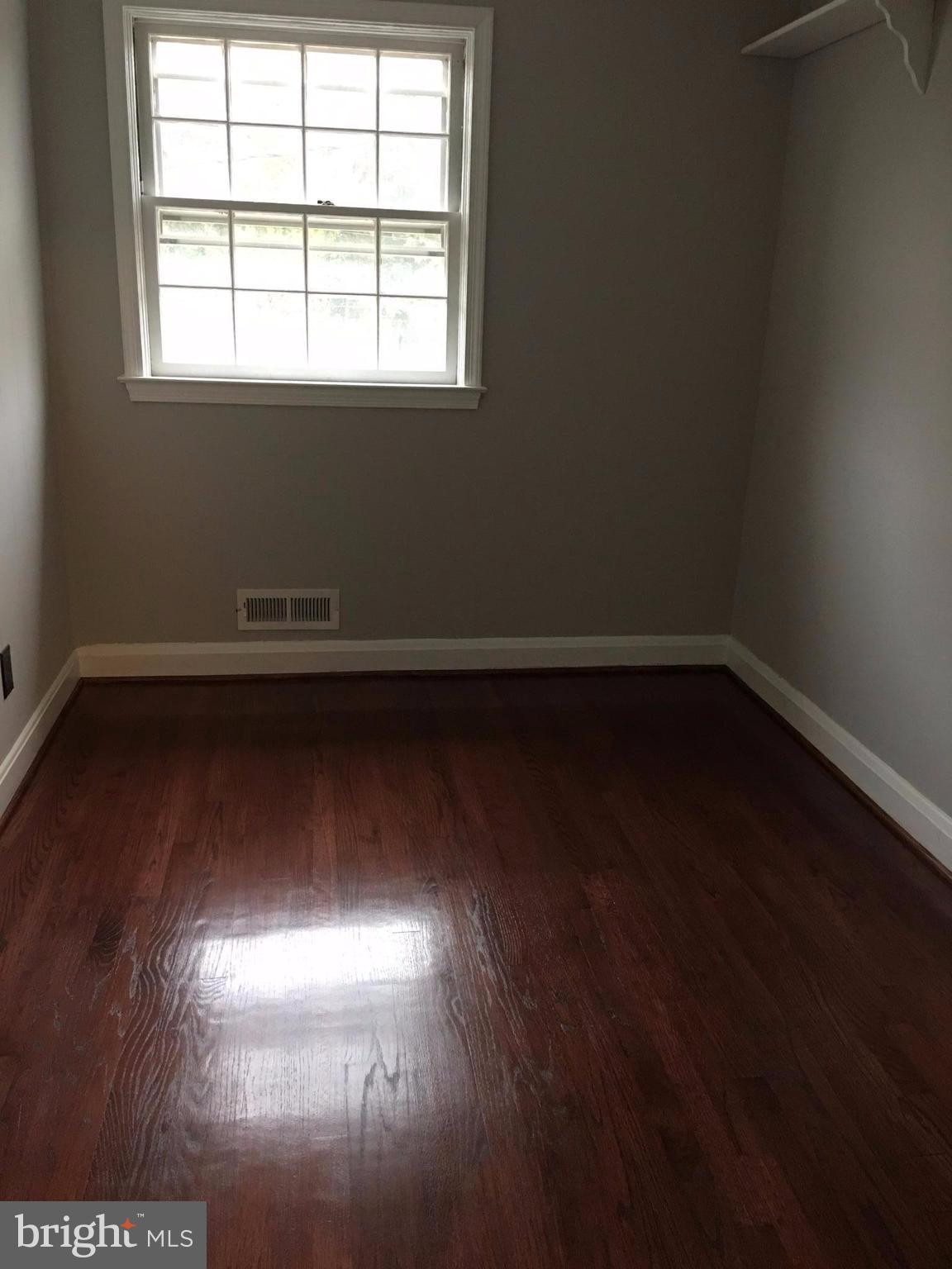 1530 Barrett Road Baltimore, MD 21207 - Photo 8 of 16 an empty room with wooden floor and windows