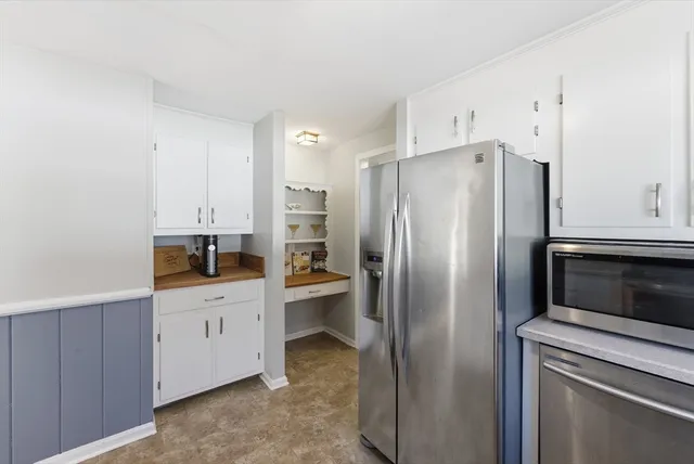 a bedroom with a large bed a flat tv screen and dresser