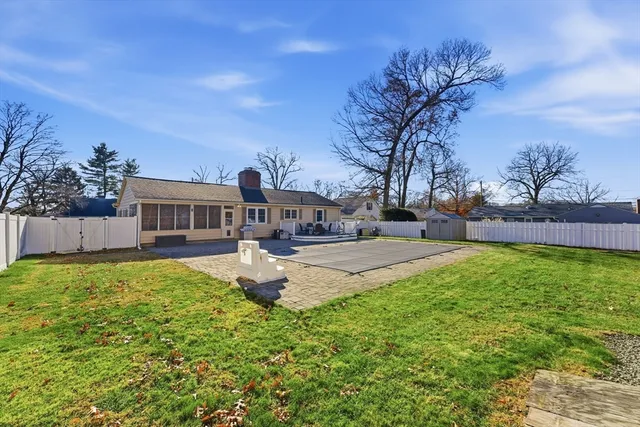 a front view of house with yard and trees in the background