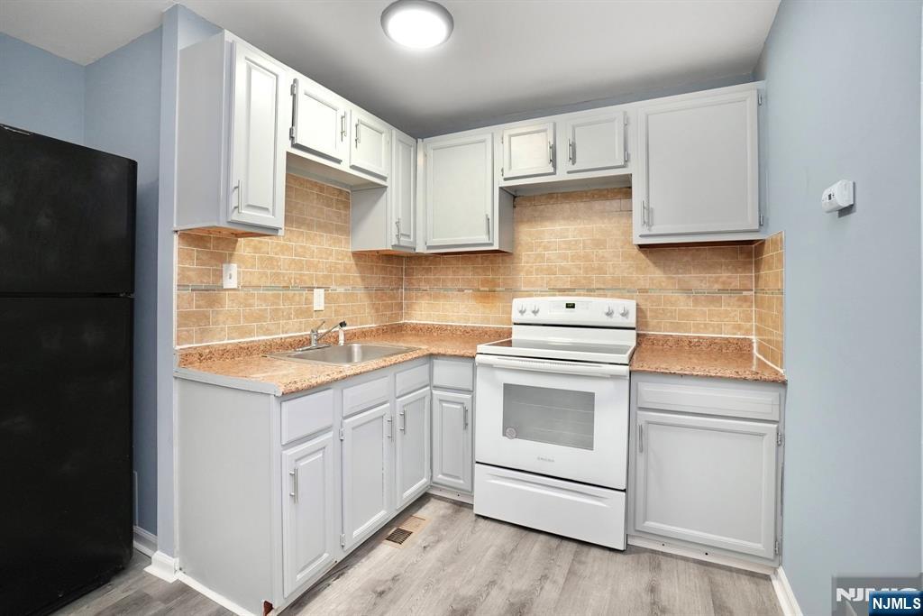 51 Demarest Street Newark, NJ 07112 - Photo 3 of 9 a kitchen with a sink stove and refrigerator