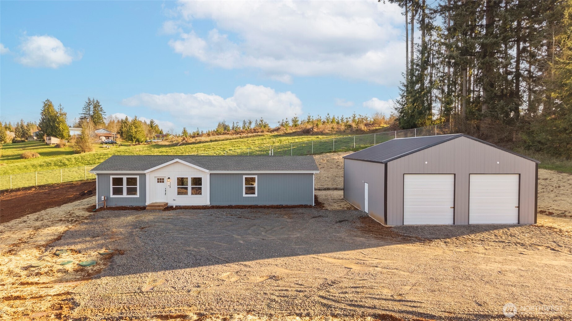 a view of a house with a yard and mountain view in back