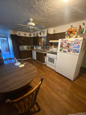 a kitchen with stainless steel appliances wooden floor and chandelier