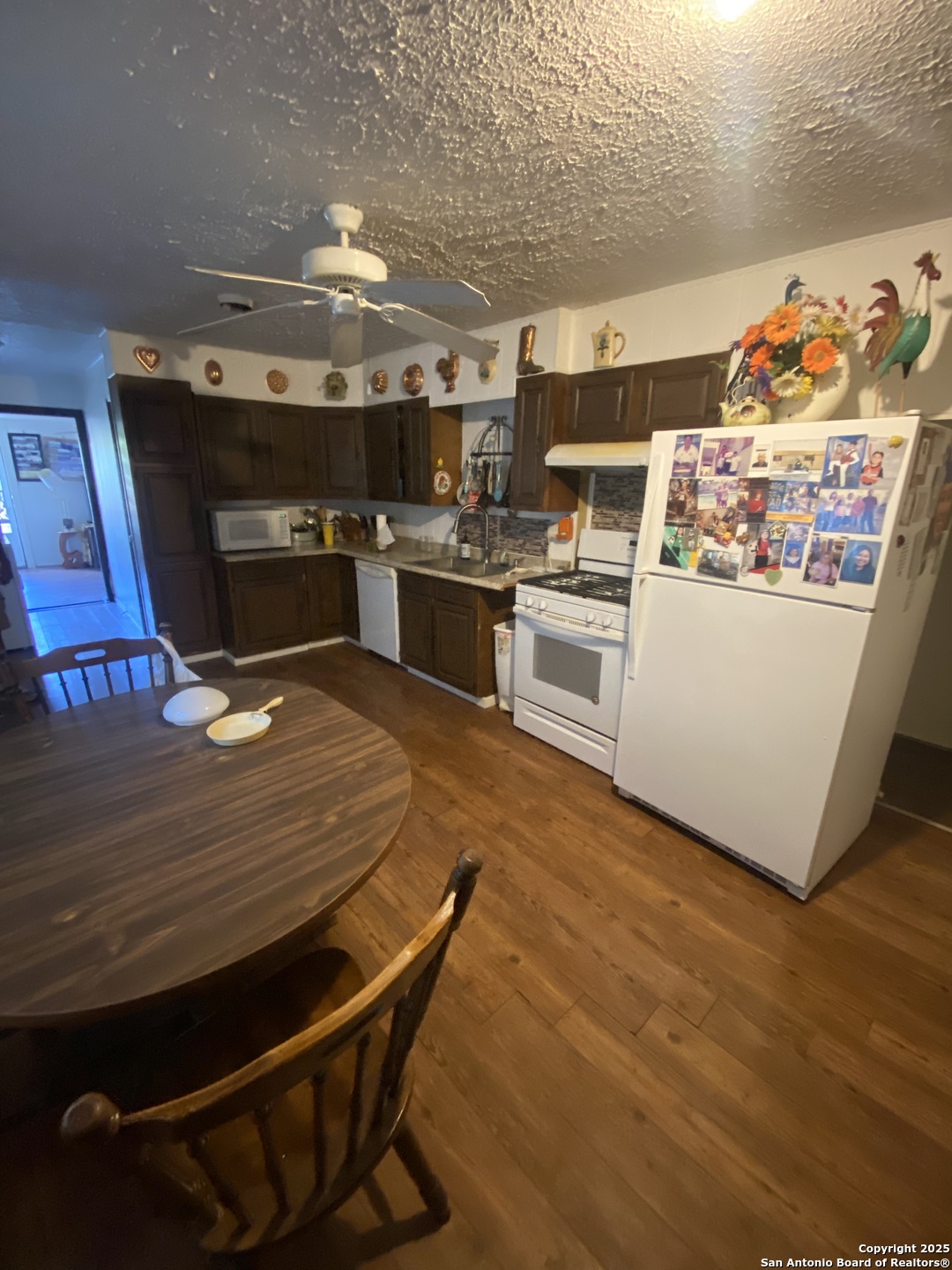 516 West Dunlap Avenue Sabinal, TX 78881 - Photo 12 of 23 a kitchen with stainless steel appliances wooden floor and chandelier
