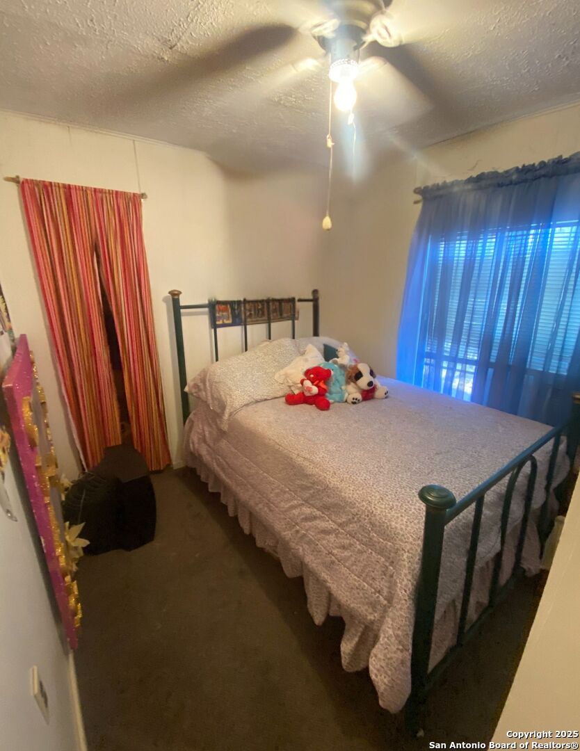 516 West Dunlap Avenue Sabinal, TX 78881 - Photo 19 of 23 a bedroom with a bed and a chandelier