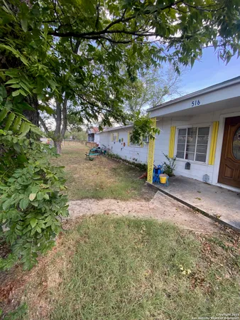 a view of a house with backyard and sitting area