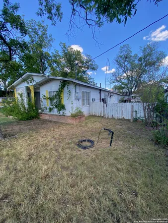 a backyard of a house with table and chairs
