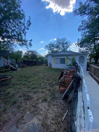 a view of a house with backyard and sitting area