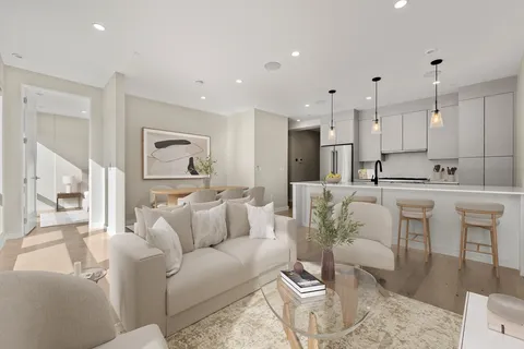a living room with furniture white walls and a view of kitchen