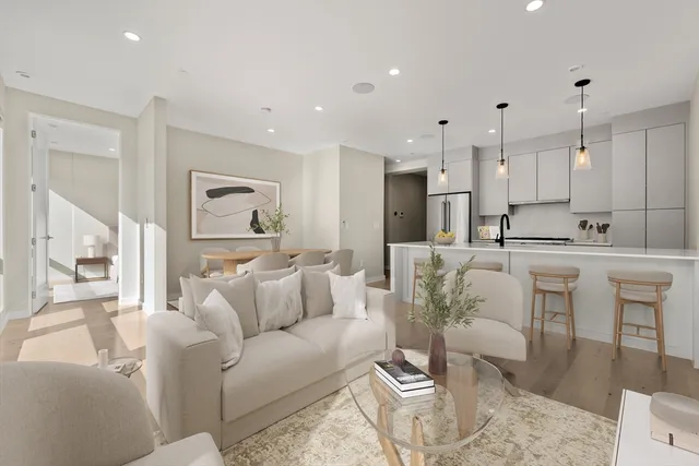 a living room with furniture white walls and a view of kitchen