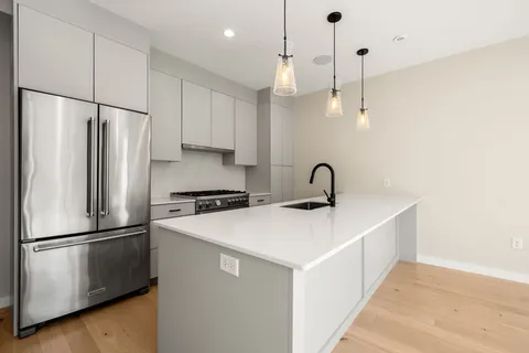 a kitchen with stainless steel appliances a refrigerator sink and cabinets