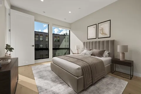 a bedroom with a large bed and a chandelier