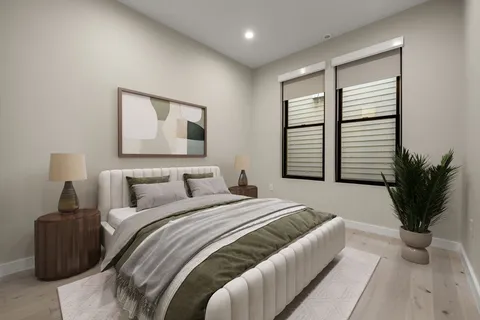 a bedroom with a large bed and a potted plant