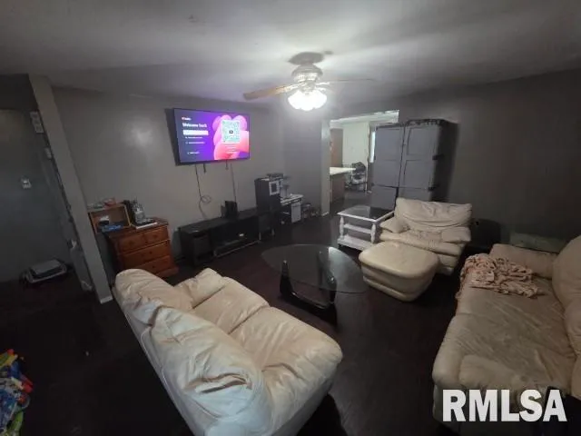a living room with furniture a chandelier and a flat screen tv