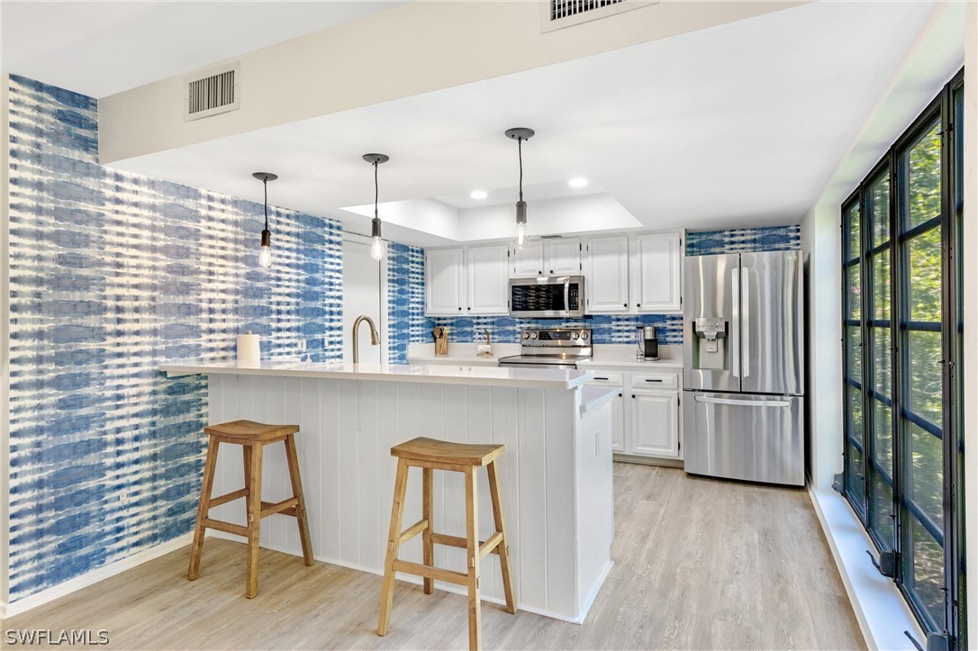 10 Sunset Captiva Lane Captiva, FL 33924 - Photo 11 of 33 a kitchen with refrigerator cabinets and wooden floor