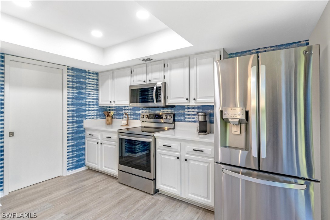 10 Sunset Captiva Lane Captiva, FL 33924 - Photo 12 of 33 a kitchen with cabinets stainless steel appliances and sink