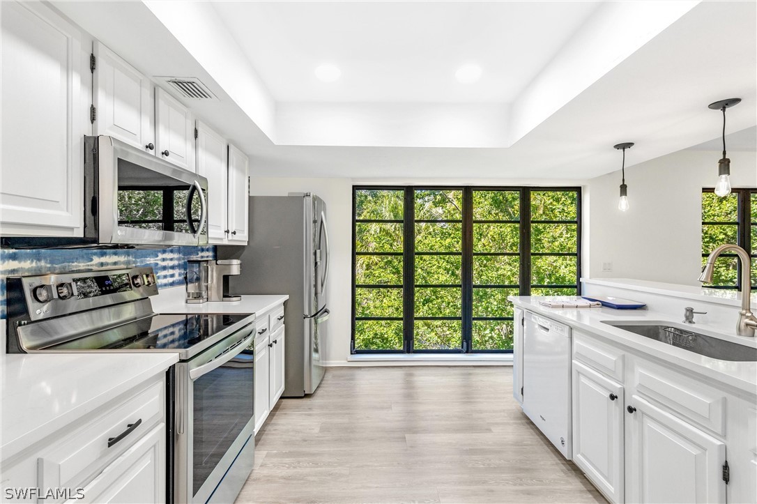 10 Sunset Captiva Lane Captiva, FL 33924 - Photo 13 of 33 a kitchen with stainless steel appliances a stove sink microwave and cabinets