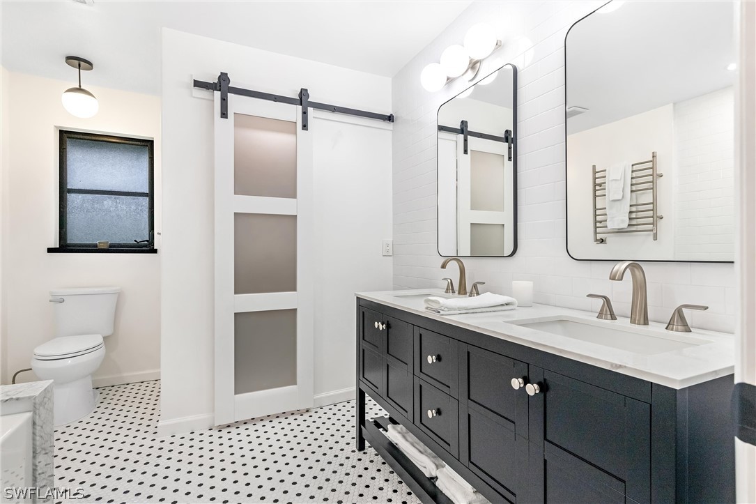 10 Sunset Captiva Lane Captiva, FL 33924 - Photo 21 of 33 a bathroom with a double vanity sink toilet mirror and shower