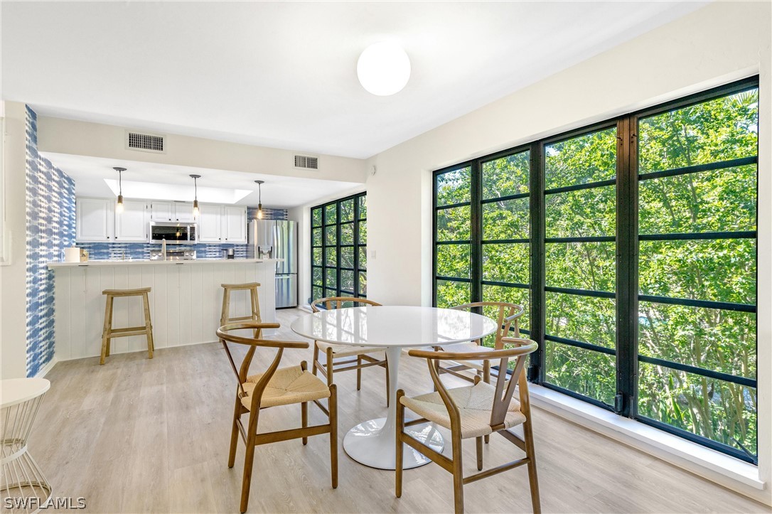 10 Sunset Captiva Lane Captiva, FL 33924 - Photo 9 of 33 a dining room with furniture and wooden floor
