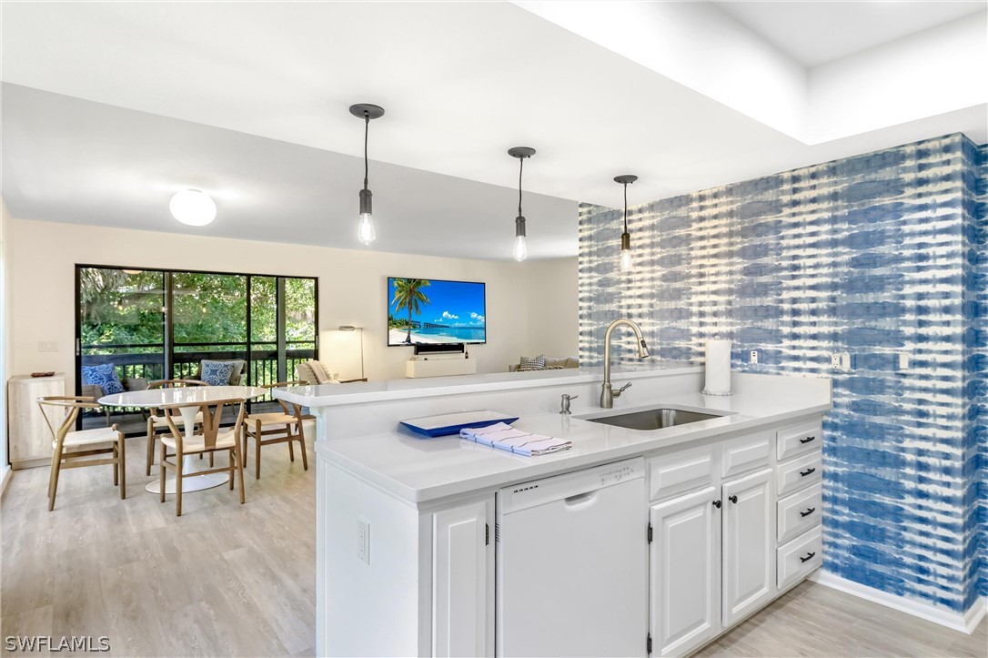 10 Sunset Captiva Lane Captiva, FL 33924 - Photo 10 of 33 a kitchen with kitchen island stainless steel appliances a table chairs sink and wooden floor